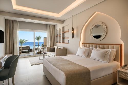 a bedroom with a bed and a living room at Sunrise Remal Beach Resort in Sharm El Sheikh