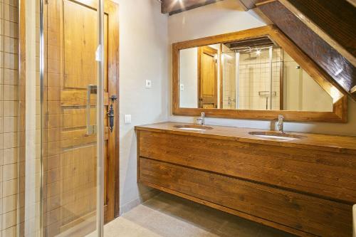 a bathroom with two sinks and a mirror at Luderna - Casa con terraza Cuylas in Baqueira-Beret