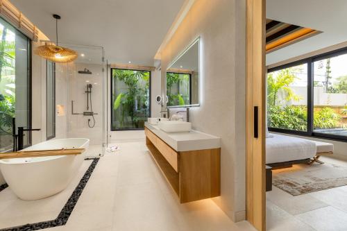 a bathroom with a tub and a sink and a bed at Layana Residence in Layan Beach