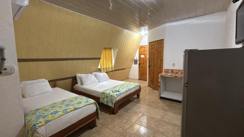 a hotel room with two beds and a bathroom at Mapi's Cabins in Paquera