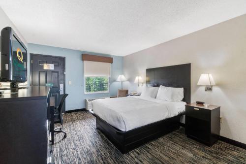 a hotel room with a bed and a flat screen tv at Quality Inn Adairsville-Calhoun South in Adairsville