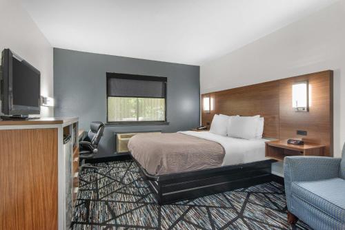 a hotel room with a bed and a flat screen tv at Quality Inn Cedartown in Cedartown