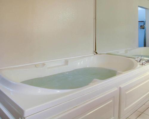 a bath tub filled with green water in a bathroom at Quality Inn & Suites Clinton - Jackson West in Clinton