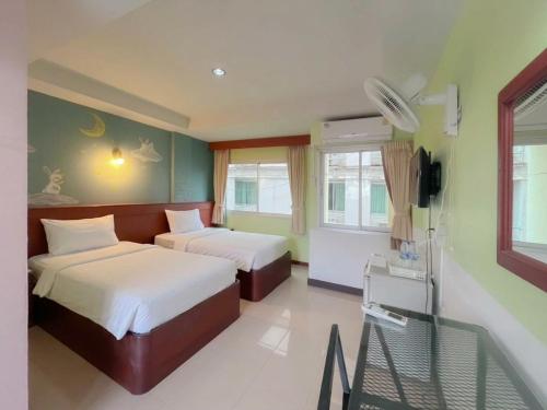 a hotel room with two beds and a television at Loei Buri Hotel by Alphatel in Ban Tha Phae