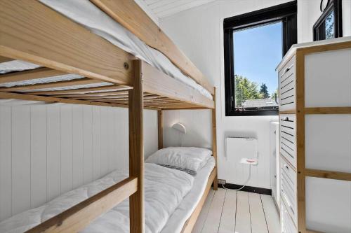 a bedroom with two bunk beds and a window at 8804-Glesborg-Vesttoften-20 in Glesborg