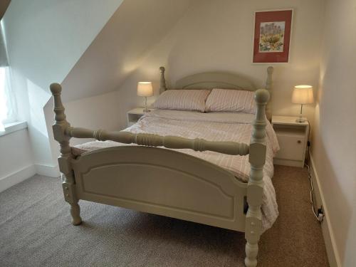 a bedroom with a bed with two lamps on both sides at Aberlour Cottages - Bolthole & Retreat in Aberlour