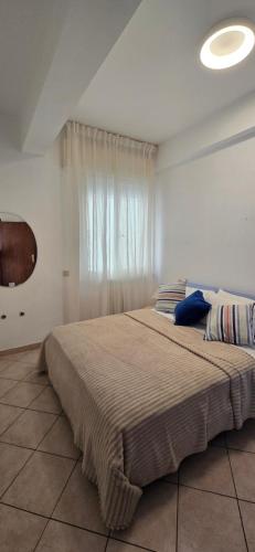 a bedroom with a large bed with a window at Casa Ida in Marotta