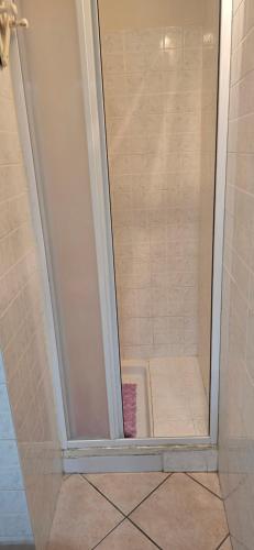 a shower with a glass door in a bathroom at Casa Ida in Marotta