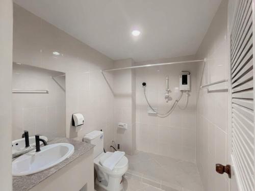 a white bathroom with a sink and a toilet at Loei Buri Hotel by Alphatel in Ban Tha Phae