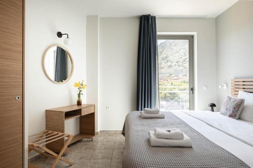 a bedroom with a bed and a mirror and a window at Bella Vista Hotel "by Checkin" in Hersonissos