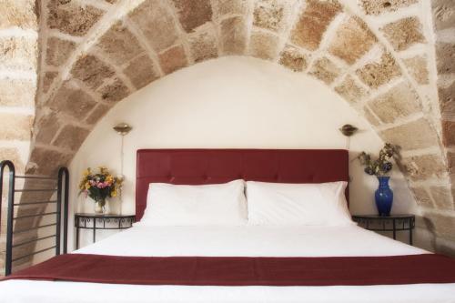 ウジェントにあるDimora Romanticaの石壁のベッドルーム1室(大型ベッド1台付)
