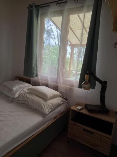 a bedroom with a bed and a large window at Sóz-Lak in Mezőcsát
