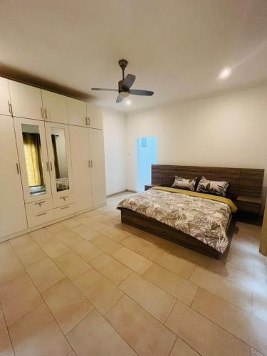 a bedroom with a bed and a ceiling fan at Teiman Apartments in Teiman