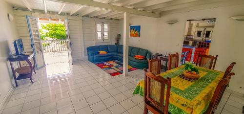a living room with a table and a blue couch at Villa bougainvillier in Les Trois-Îlets