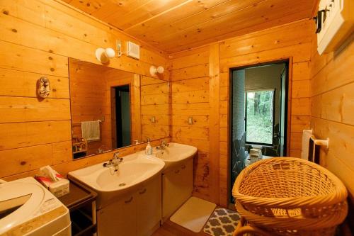 a bathroom with a sink and a mirror in a cabin at ログハウス那須ハイグランド in Nasu