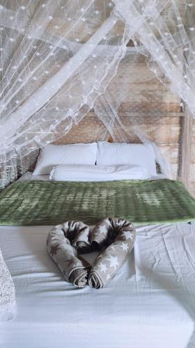 a bed with a comforter on top of it at BRIGHT Guest Hause in Besir