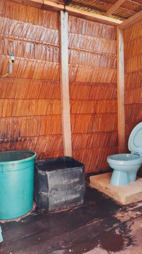a bathroom with a toilet and a blue bucket at BRIGHT Guest Hause in Besir