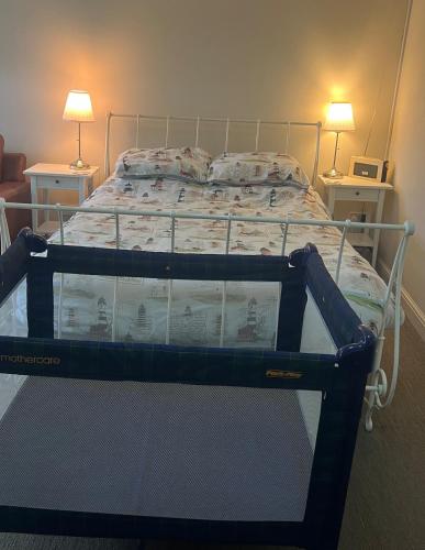 a bed in a bedroom with two tables and two lamps at Fishermans Rest in Newport