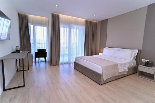 ein Schlafzimmer mit Bett, Schreibtisch und Fenster in der Unterkunft E-88 Hotel in Tirana