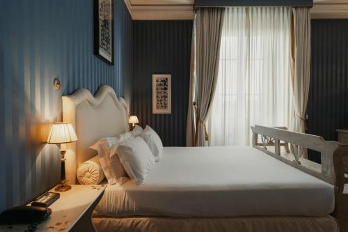 a bedroom with a large white bed and a window at Hotel Palazzo Guiscardo Pietrasanta in Pietrasanta
