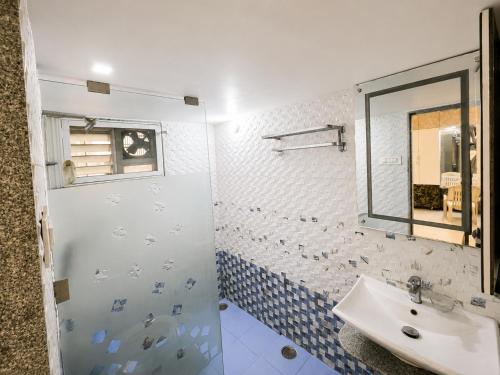 a bathroom with a sink and a mirror at Ansh Bunglow in Belgaum