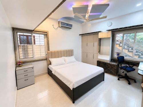 a bedroom with a bed and a desk and a chair at Ansh Bunglow in Belgaum