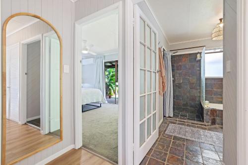 a hallway with a mirror and a walk in shower at The Hideaway in Bargara