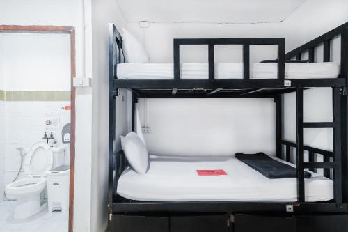 a room with three bunk beds and a bathroom at Blanco Central in Phi Phi Islands