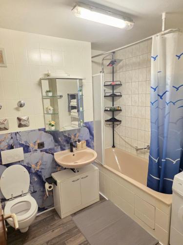 a bathroom with a toilet and a sink and a tub at HappyNest in Böblingen