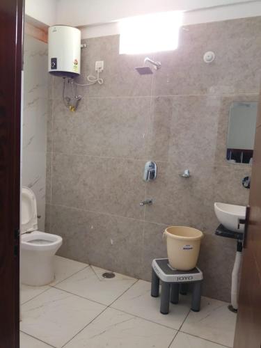 a bathroom with a toilet and a sink at Hotel Shri Mahavir in Chamoli