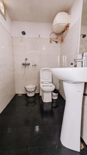 a bathroom with a white sink and a toilet at Hotel Best Inn in Darjeeling