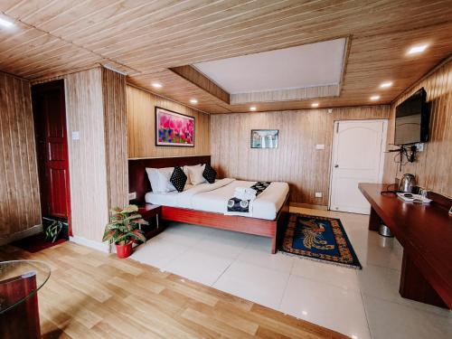a bedroom with a bed in a room with wooden walls at Hotel Best Inn in Darjeeling