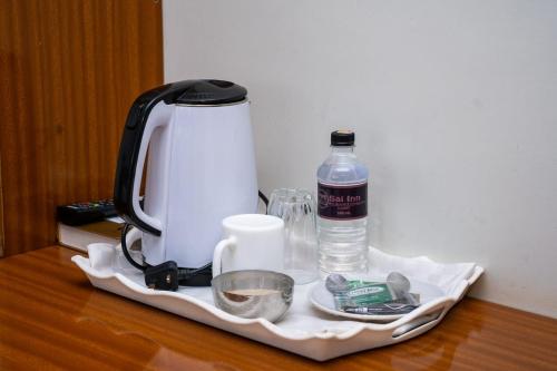 a tea kettle and a bottle of water on a table at Sai Inn Eldoret in Eldoret