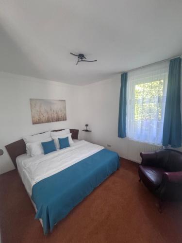a bedroom with a large bed and a chair at Six Apartman in Bükfürdő