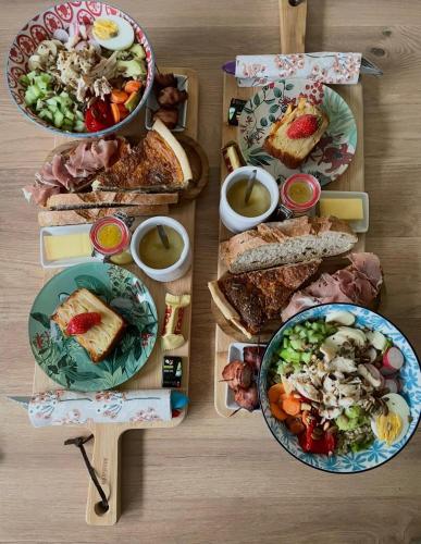 a table topped with plates of food and salads at La Casa du Vau - Tiny House in Bussy-le-Grand