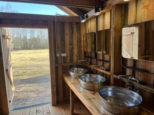 a row of three metal bowls on a wooden counter at Malowane Wrota Camp - Gniazdko in Łazy