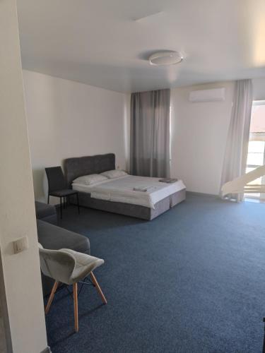 a bedroom with a bed and a couch and a chair at Zarvanska str apartment in Kamianets-Podilskyi