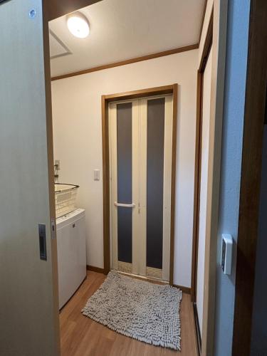 a hallway with a door and a rug in a room at ENZAN STAYS Yamanashi in Enzan