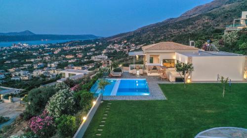 a villa with a swimming pool and a house at Villa Kedria with a panoramic ocean view in Souda