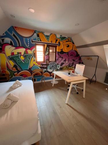 a room with a graffiti wall with a desk and a laptop at Le Plébiscité Maison Premium sur la Route des Vins d'Alsace in Marlenheim