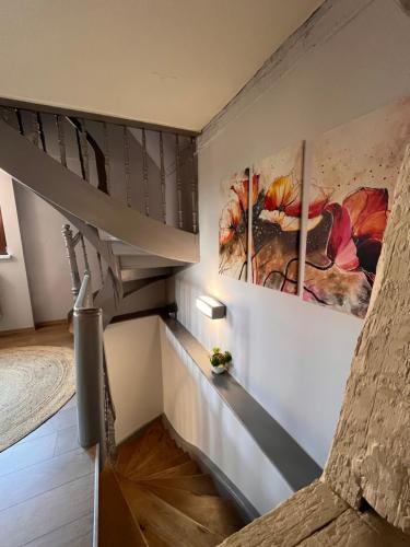 a staircase in a house with paintings on the wall at Le Plébiscité Maison Premium sur la Route des Vins d'Alsace in Marlenheim