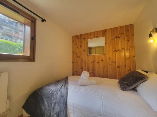 a bedroom with a large white bed with a window at Residence Isabella - By Care Concierge in Saint-Gervais-les-Bains