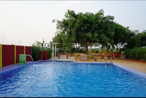 a large swimming pool in a yard at Rupani Dhani Farm Stay in Gurgaon