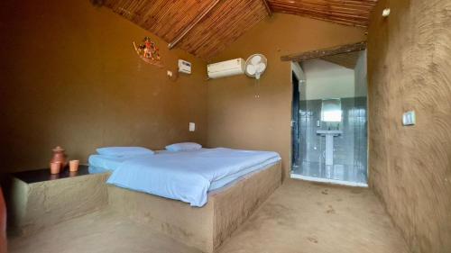 a bedroom with a large bed and a bathroom at Rupani Dhani Farm Stay in Gurgaon
