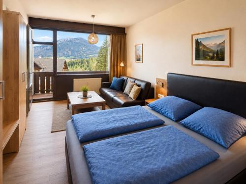 a bedroom with a bed and a living room with a couch at Dachstein Blick in Bad Goisern