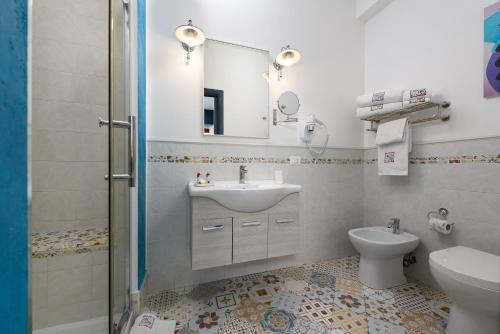 a bathroom with a sink and a toilet and a mirror at Athena Bed & Breakfast in San Vito lo Capo
