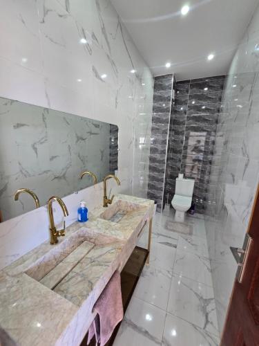 a bathroom with a marble sink and a toilet at Villa Sabrina in Moulay Bousselham