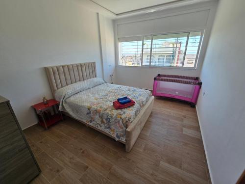 a small bedroom with a bed and a window at Villa Sabrina in Moulay Bousselham