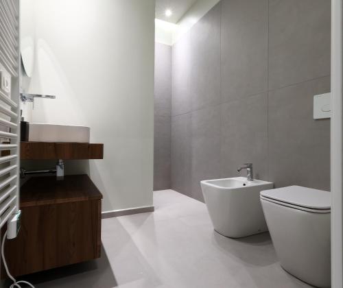 a white bathroom with a sink and a toilet at Rooms Residence Rubiera in Rubiera
