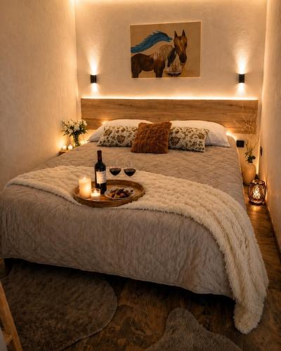 a bedroom with a bed with a tray with wine bottles and candles at Záhradný domček pri Slovenskom raji in Smižany